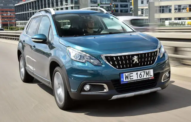 Turkusowy Peugeot 2008 na drodze. Kierowca w środku. Wiele pozytywnych peugeot 2008 opinie o tym modelu.