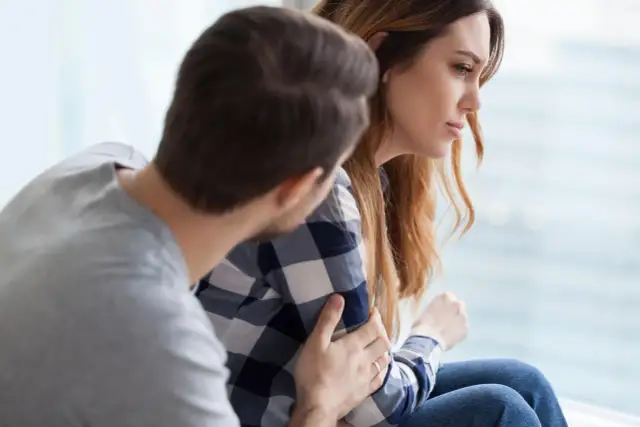 Mężczyzna pociesza kobietę, która zmaga się z trudnościami. Czy zaburzenia adaptacyjne to choroba psychiczna?