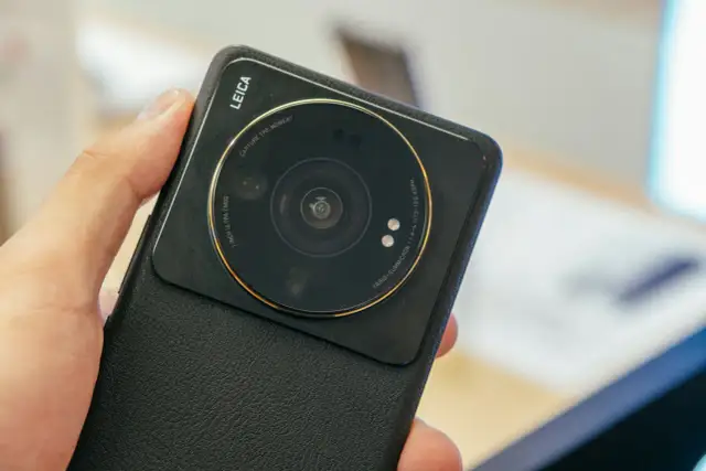 Dłoń trzyma czarny telefon Xiaomi z dużym modułem aparatu Leica.