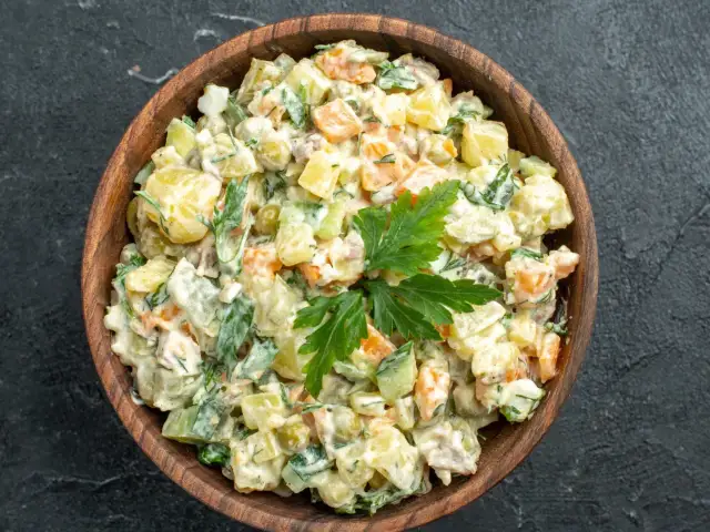 Pyszna sałatka jarzynowa w drewnianej misce, idealna na rodzinne spotkania. Oto nasze 4 wypróbowane sałatki!