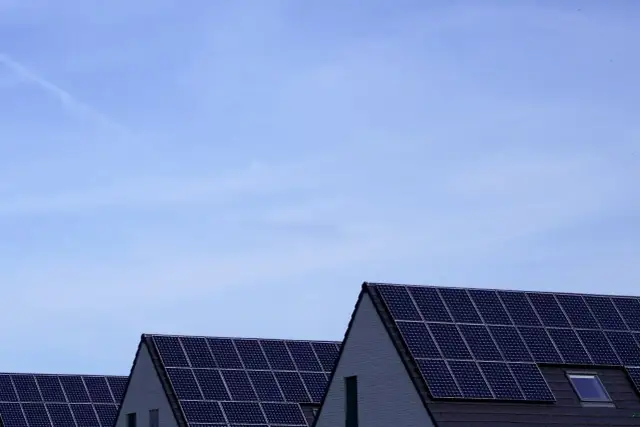 Dachy domów pokryte panelami fotowoltaicznymi. Stabilizator napięcia fotowoltaika zapewnia optymalną pracę instalacji.