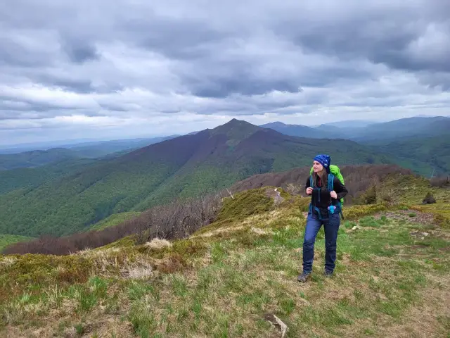 Kobieta z plecakiem na tle górskiego krajobrazu, szlak czerwony beskidzki.