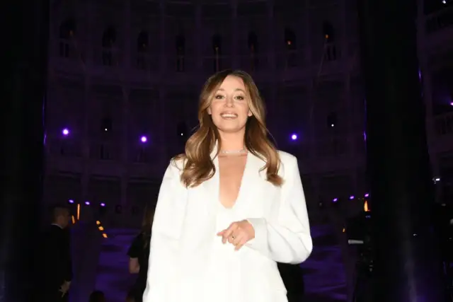 Iza Krzan w białym garniturze, uśmiechnięta, na tle fioletowych świateł. Kto ubiera Izę Krzan w Kole Fortuny?