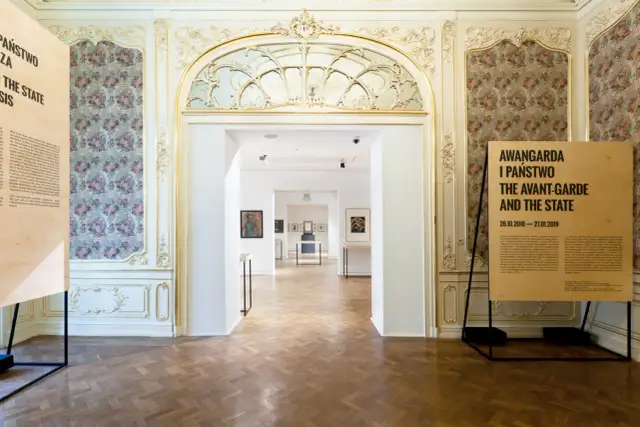 Wnętrze muzeum z tablicami informacyjnymi i widokiem na sale wystawowe.