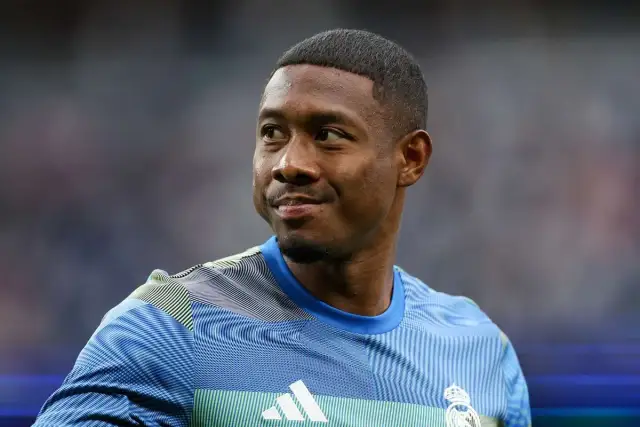 Piłkarz David Alaba w niebieskiej koszulce z białym logo Adidas i herbem Realu Madryt.