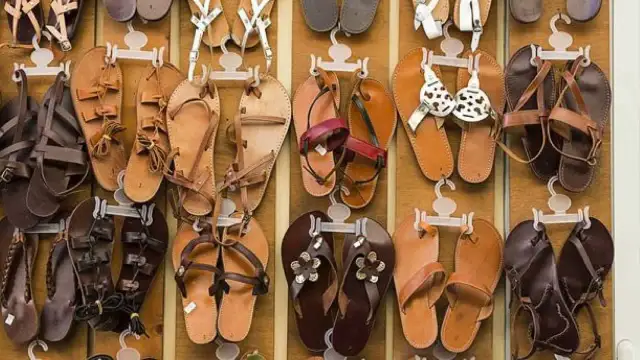 Wiele par skórzanych sandałów wiszących na wieszakach.