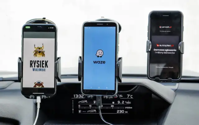 Trzy telefony w uchwytach na desce rozdzielczej: z lewej Rysiek, w środku Waze, a po prawej Yanosik. Którą nawigację wybierzesz?