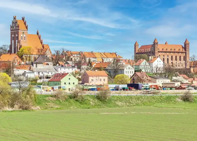 Zamek w Gniewie - ciekawostki. Imponująca twierdza i urokliwe miasteczko na tle błękitnego nieba.