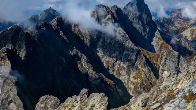 Surowe szczyty Tatr, gdzie chmury tańczą wokół skalnych grani. Tu znajdują się jakie są najwyższe góry w Polsce.