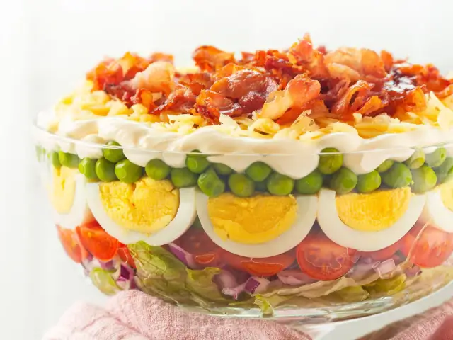 Warstwowa sałatka z boczkiem, serem i jajkiem. Idealna, gdy potrzebujesz szybka sałatka dla gości.