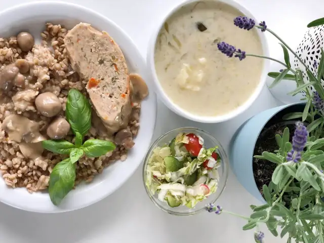Kotlet mielony z kaszą, grzybami i surówką, obok miseczka zupy i lawenda.