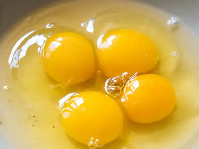 Cztery żółtka jaj w misce. Czy pies może jeść surowe żółtko? To pytanie nurtuje wielu właścicieli czworonogów.
