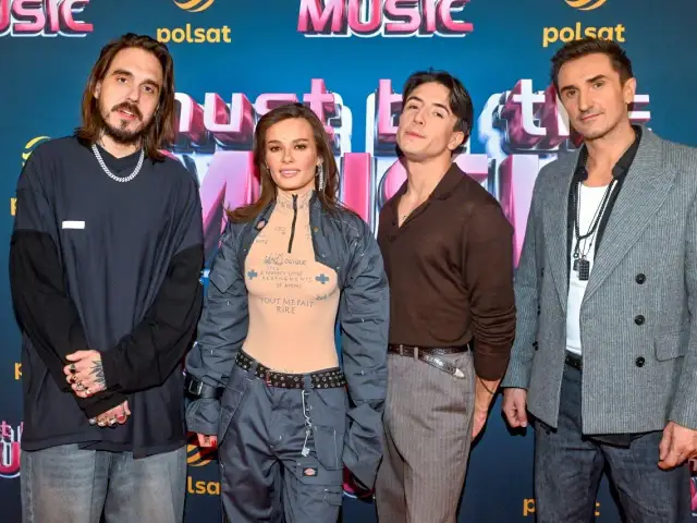 Czterech artystów na ściance z napisem "must be the music". Wokalistka w odważnej stylizacji z tatuażami na dekolcie.