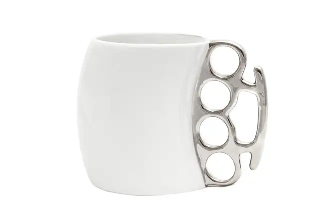 Biały kubek z metalowym uchwytem w kształcie kastetu.