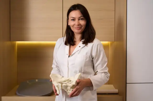 Położna środowiskowa z modelem miednicy, gotowa odpowiedzieć na Twoje pytania.