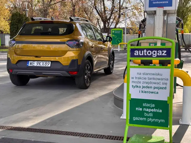 Żółty Dacia Sandero Stepway na stacji autogazu. Kierowca sprawdza dacia sandero stepway spalanie przed tankowaniem.