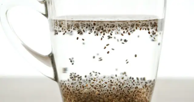 Szklanka z wodą i nasionami chia, gotowa do spożycia. Dowiedz się, jak pić nasiona chia dla zdrowia.