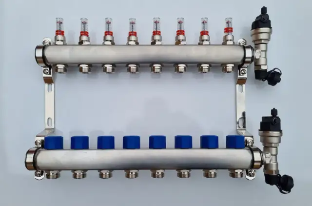 Rozdzielacz do pompy ciepła ze stali nierdzewnej z przepływomierzami i niebieskimi zaślepkami.