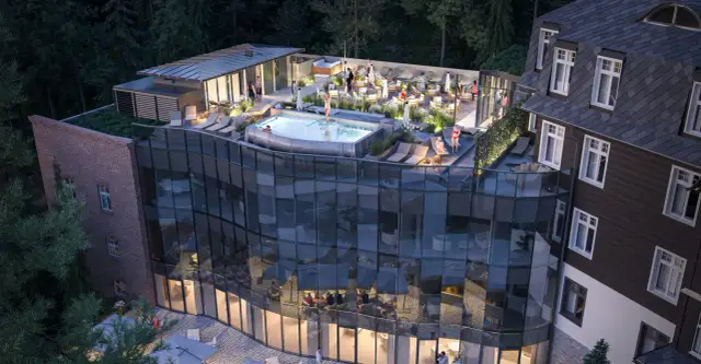 Nowoczesny taras z basenem i leżakami przy hotelu Sanssouci Karpacz. Goście relaksują się w otoczeniu zieleni.