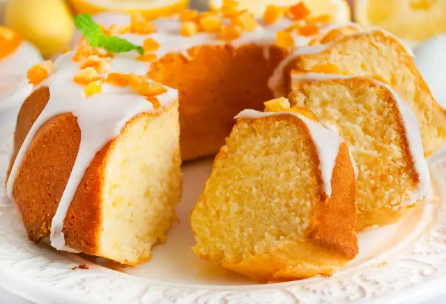 Puszysta babka wielkanocna cytrynowa, polana lukrem i posypana kandyzowaną skórką cytrynową, prezentuje się apetycznie.