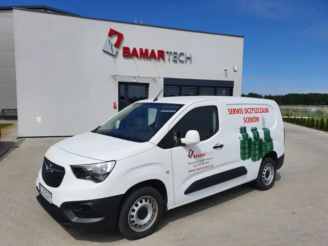 Biały van z logo BAMARTECH i grafiką oczyszczalni ścieków. Firma oferuje serwis, odpowiadając na pytanie: jak często trzeba opróżniać przydomową oczyszczalnię ścieków przepisy.