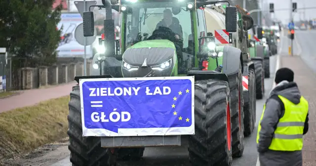 Traktory z transparentem "Zielony Ład = Głód" na tle deszczu. Rolnicy protestują przeciwko polityce UE.