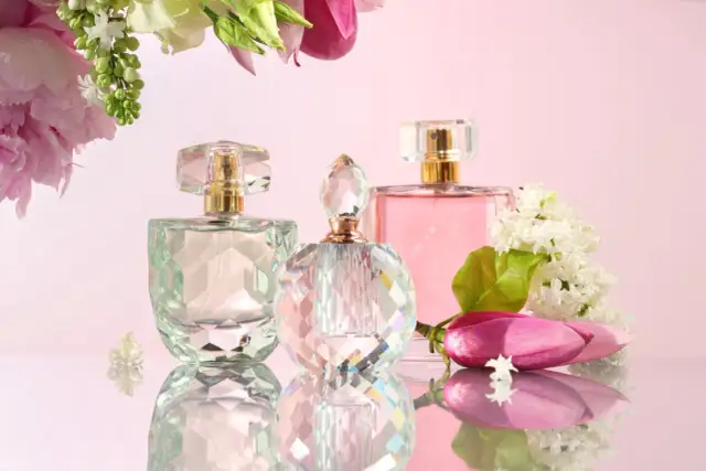 Eleganckie flakony perfum i kwiaty. Zastanawiasz się, ile kosztują perfumy?