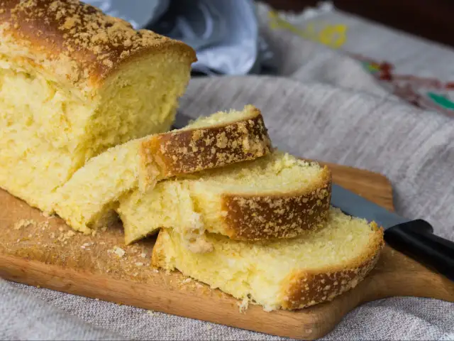 Szybki placek drożdżowy z kruszonką, pokrojony na desce, gotowy do podania.