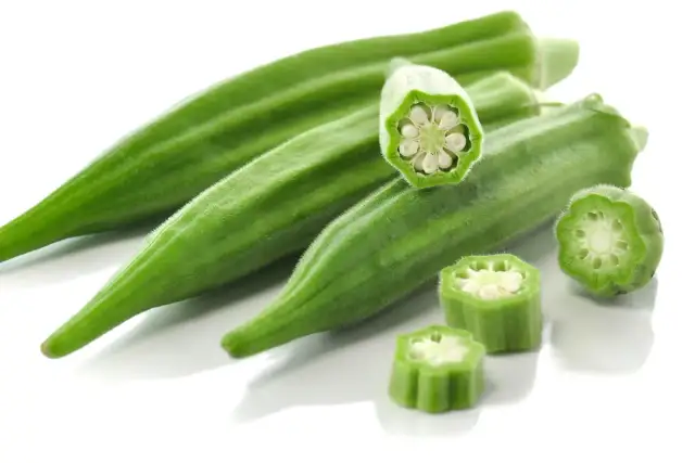 Kilka zielonych strąków okry, w tym przekrojone, ukazujące nasiona. Okra po polsku to pyszny dodatek do dań.