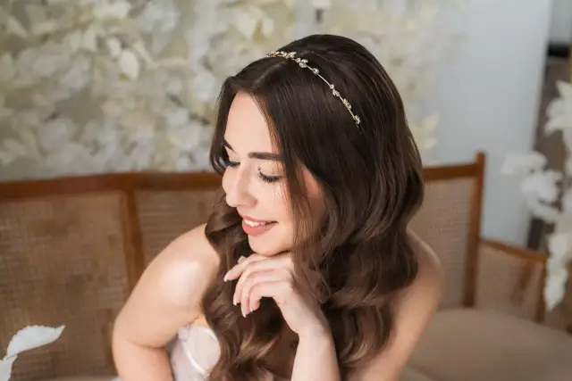 Delikatna tiara ślubna Swarovski zdobi włosy brunetki, dodając blasku jej ślubnej stylizacji.