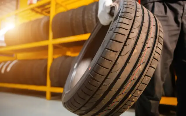 Nowe opony na żółtej półce. Czy koło zapasowe jest obowiązkowe? Warto mieć zapas, gdy coś się stanie.