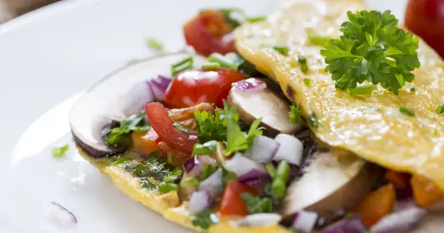 Omlet z pieczarkami, pomidorkami i cebulką. Idealna wysokobiałkowa kolacja, pełna smaku i zdrowych składników.