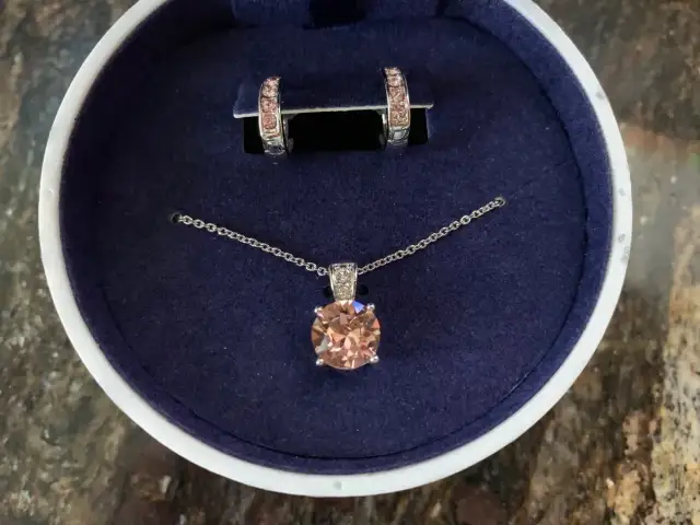 Eleganckie **Swarovski komplety**: naszyjnik z brzoskwiniowym kryształem i kolczyki w pudełku.