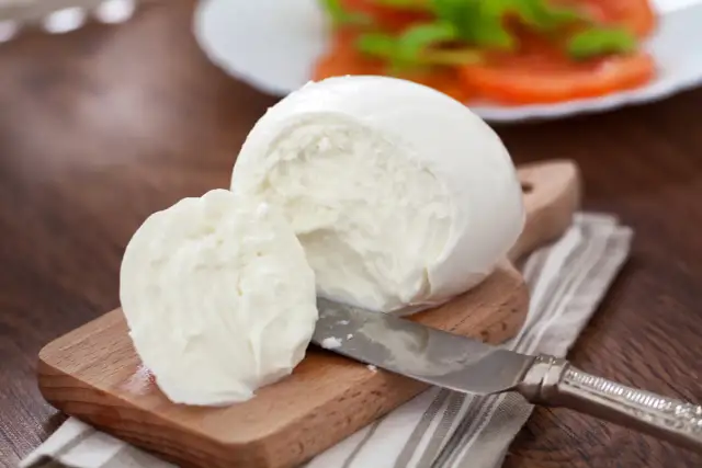Świeża mozzarella na desce, gotowa do sałatki. Czy mozzarella jest wegetariańska? Tak, tradycyjnie tak!