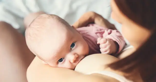 Niemowlę karmione piersią, z bliska, z matką.