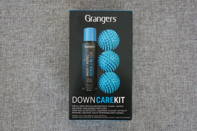 Zestaw Grangers Down Care Kit zawiera płyn do prania kurtek puchowych i 3 niebieskie piłeczki do suszarki, które pomagają odzyskać objętość.