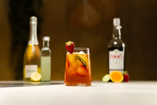 Orzeźwiający drink z Pimm's No. 1, truskawkami i ogórkiem, w kontraście do Aperol Spritz.