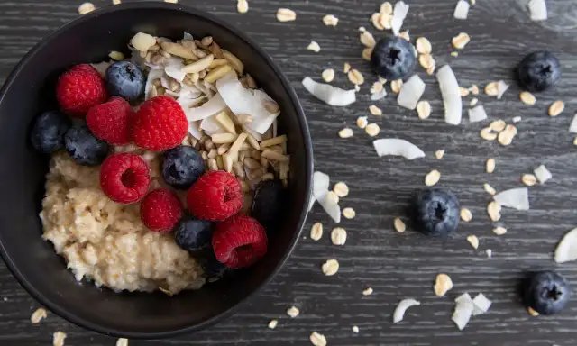 Pyszny przepis na zdrową owsiankę z malinami, borówkami i wiórkami kokosowymi. Idealne śniadanie pełne witamin.