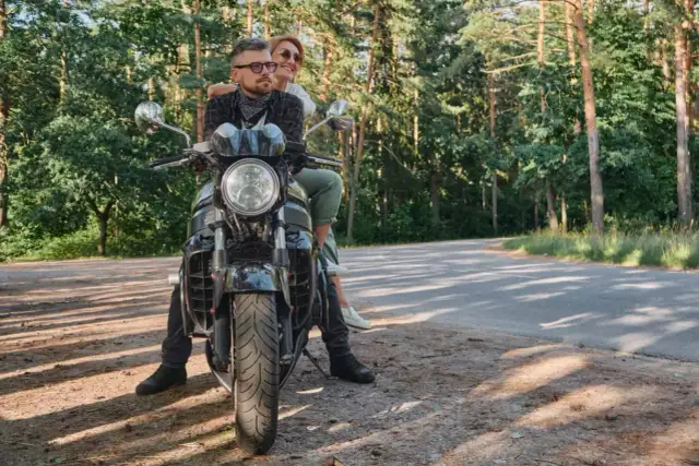 Para z uśmiechem na twarzy, podróżująca motocyklem po malowniczych Kaszubach.