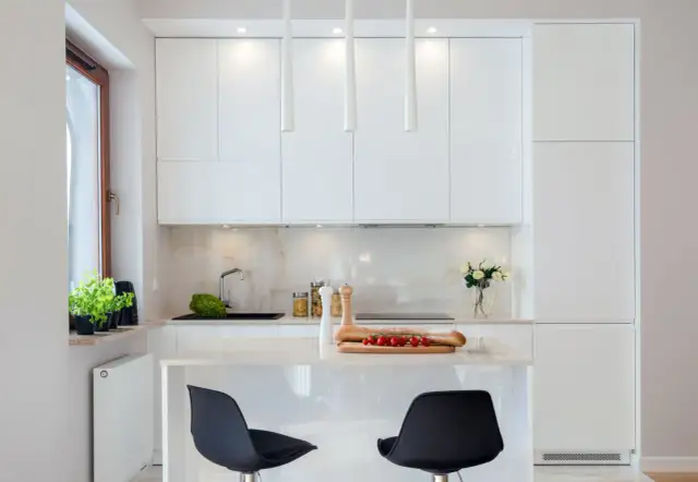 Jak wypełnić przestrzeń między szafkami w białej kuchni, aby zyskać styl?