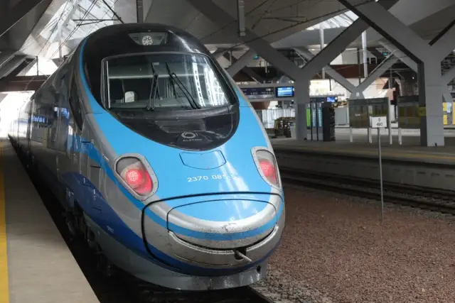 Przód niebiesko-srebrnego pociągu PKP Pendolino na peronie.