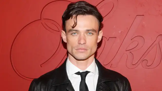 Thomas Doherty, znany z filmów, seriali i programów, prezentuje się w skórzanej kurtce i eleganckiej koszuli.