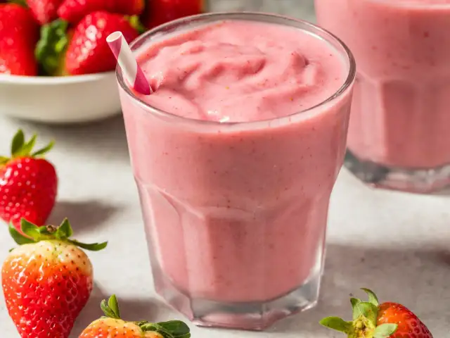 Pyszny, różowy koktajl truskawkowy z papierową słomką. Idealny przepis na zdrowe słodycze, który zachwyci każdego.