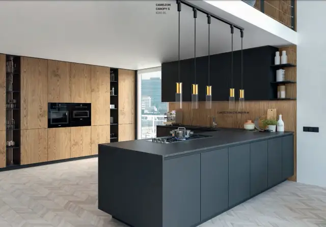 Nowoczesna kuchnia z wyspą, nad którą wisi efektowne oświetlenie.