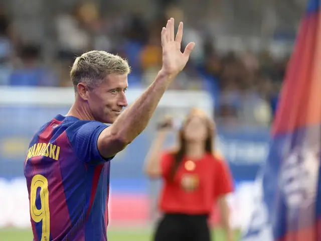 Robert Lewandowski w koszulce Barcelony wznosi rękę. Czy Barcelona odpadła z Ligi Mistrzów?