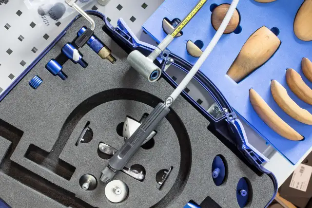 Zestaw narzędzi do odbarczania butów narciarskich, z drewnianymi kopytami i precyzyjnymi elementami.