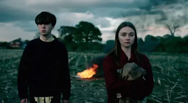 Dwójka młodych ludzi stoi na polu, za nimi płonie ognisko. To może być **the end of the f***ing world**.