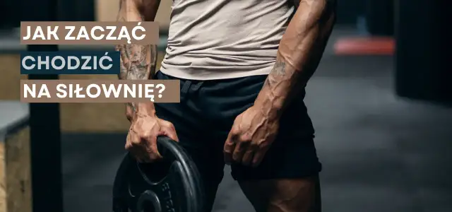 Jak zacząć chodzić na siłowni? Mężczyzna z wytatuowanymi ramionami trzyma talerz obciążenia, gotowy do treningu.