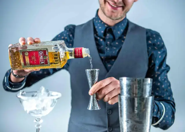 Barman nalewa Tequilę Silver czy Reposado do Margarity. W tle kieliszek z lodem i shaker.