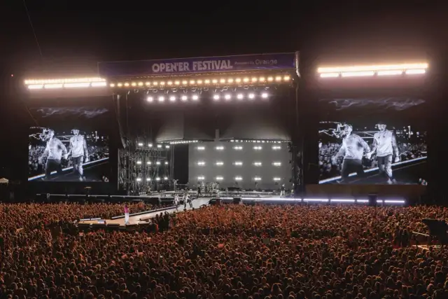 Ogromny tłum na Opener Festival, **ile ludzi**! Na scenie artyści, a na telebimach ich wizerunki.